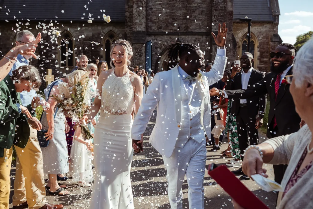 Confeti shot of wedding couple outside a church- candid wedding photographer