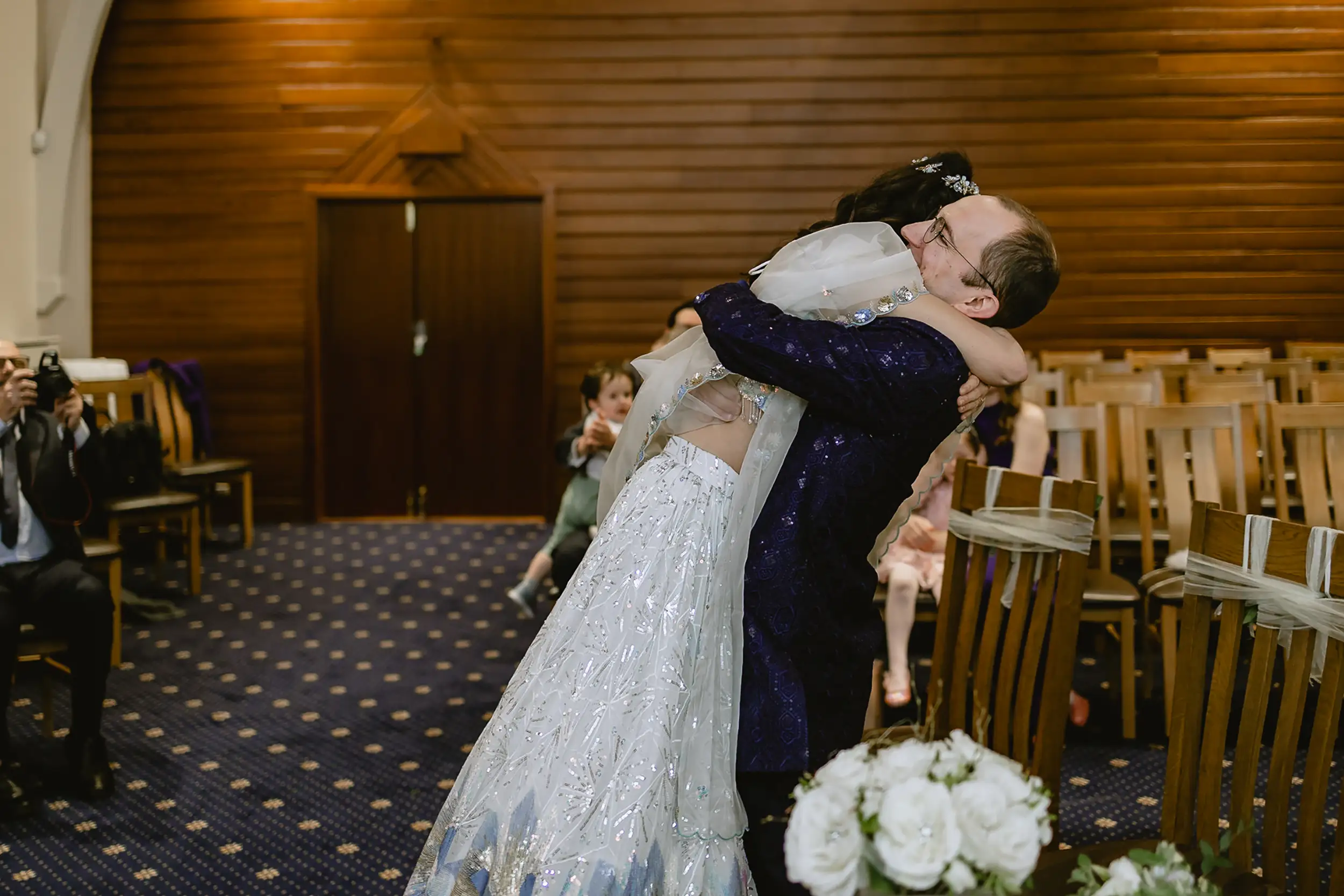 The bride and groom sharing a joyful hug at the altar after being married, a candid moment from a session of small wedding photography in Southampton by VasPhotography