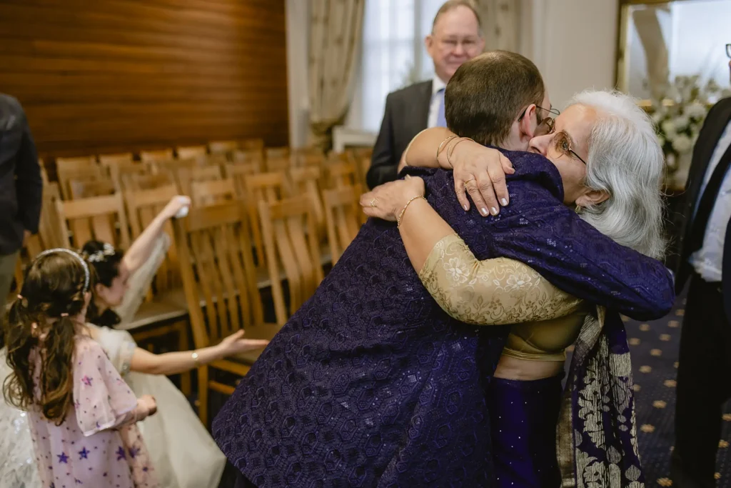 The groom sharing a warm, emotional hug with a family member after the ceremony, illustrating the intimate storytelling of small wedding photography in Southampton by VasPhotography