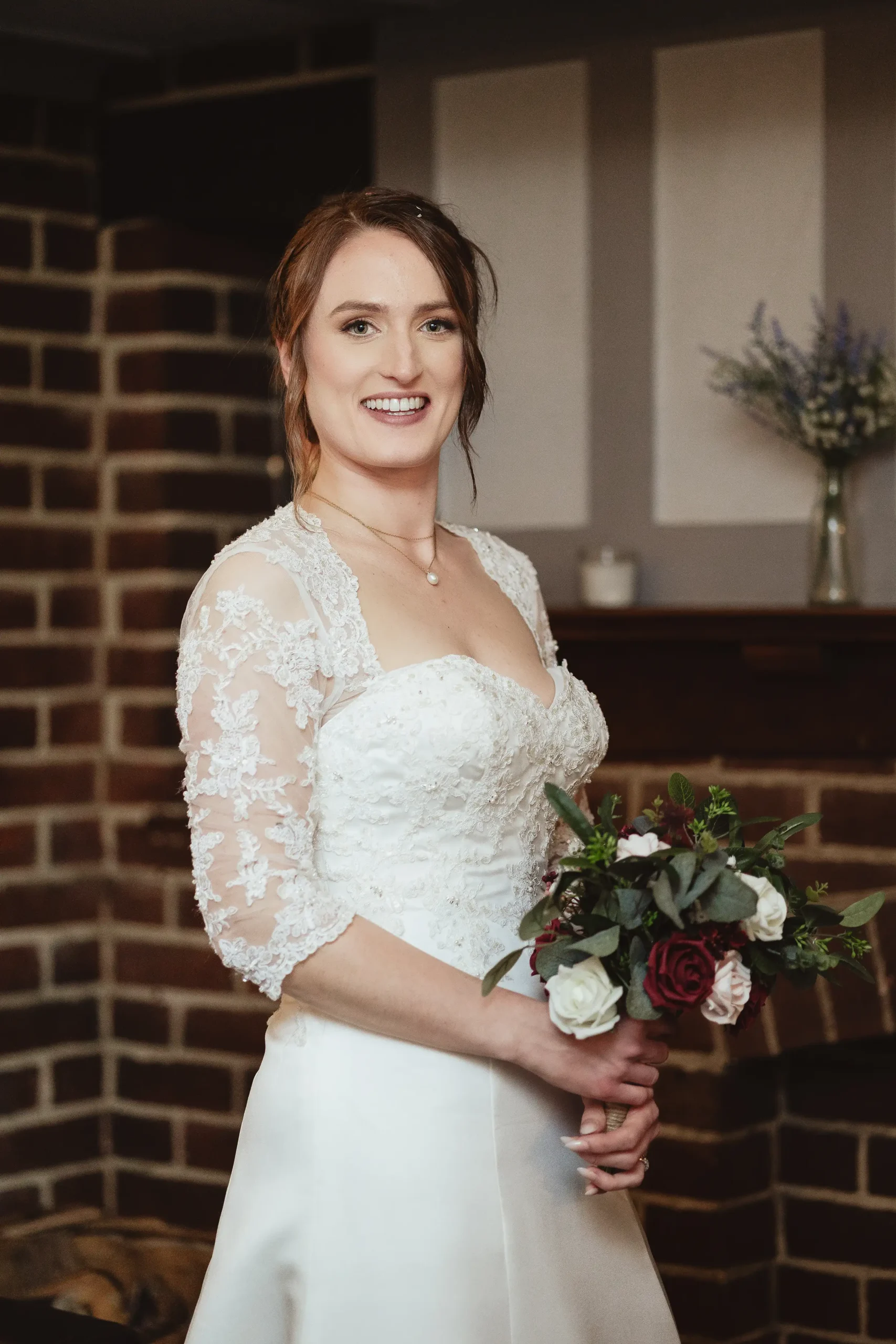Editorial bridal portrait with lace sleeves in a moody indoor corner at Ampfield Golf Club