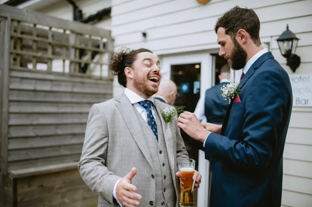 groom and best man having a laugh at The Angel Hotel, Alton, Hampshire — candid wedding photography by VasPhotography