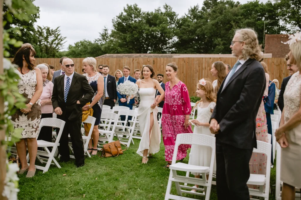 bride walking on the isle , outside ceremony at The Angel Hotel, Alton, Hampshire — candid wedding photography by VasPhotography