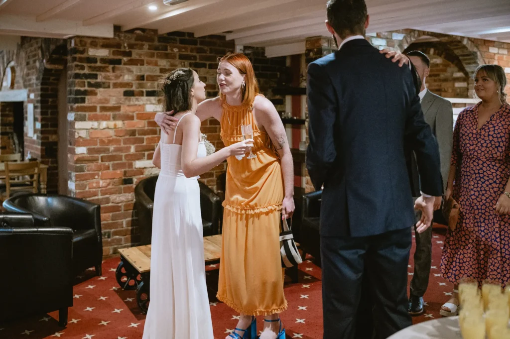 bride being hugged at The Angel Hotel, Alton, Hampshire — candid wedding photography by VasPhotography