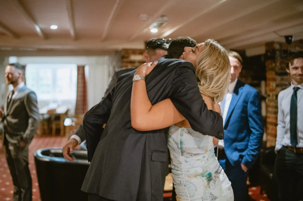 two people hug at The Angel Hotel, Alton, Hampshire — candid wedding photography by VasPhotography