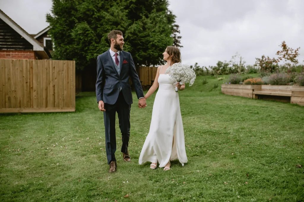 bride and groom walking in the garden at The Angel Hotel, Alton, Hampshire — candid wedding photography by VasPhotography
