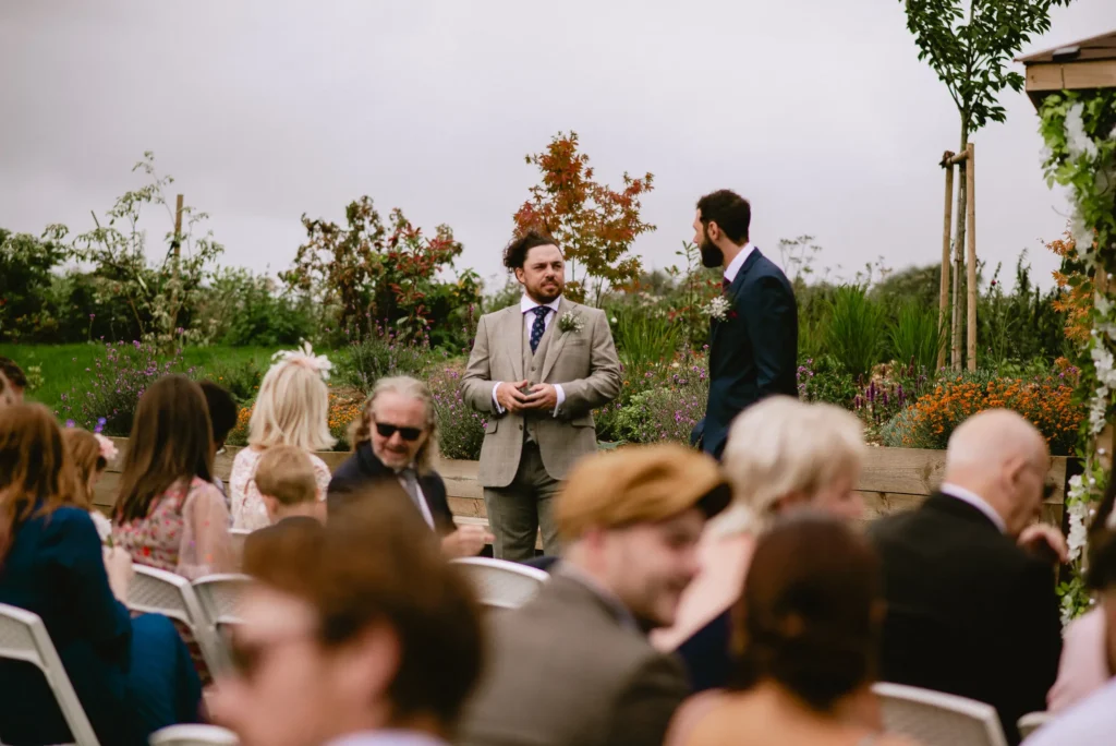 groom and best man waiting for the bride in the middle of their guests at The Angel Hotel, Alton, Hampshire — candid wedding photography by VasPhotography