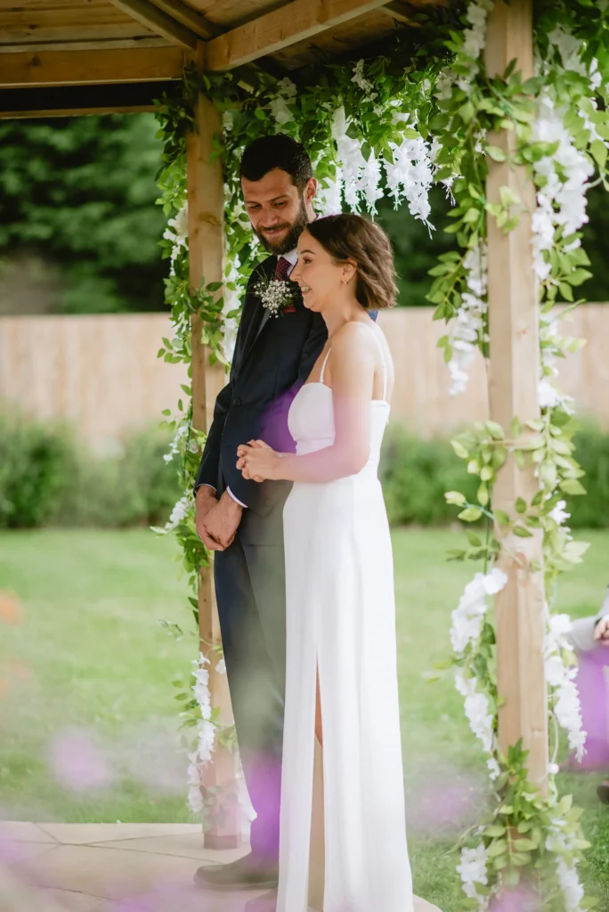 candid bride and groom photo while the ceremony at The Angel Hotel, Alton, Hampshire — candid wedding photography by VasPhotography