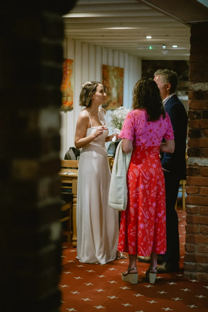 bride having a moment with guests at The Angel Hotel, Alton, Hampshire — candid wedding photography by VasPhotography