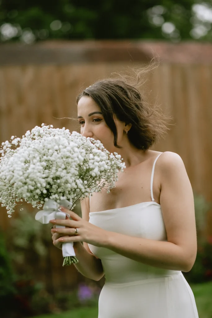 bride smelling flowers at The Angel Hotel, Alton, Hampshire — candid wedding photography by VasPhotography