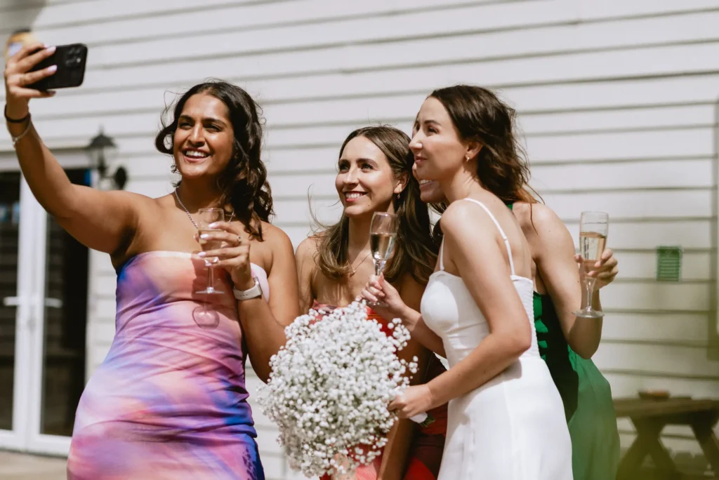 bride and girls taking a selfie at The Angel Hotel, Alton, Hampshire — candid wedding photography by VasPhotography