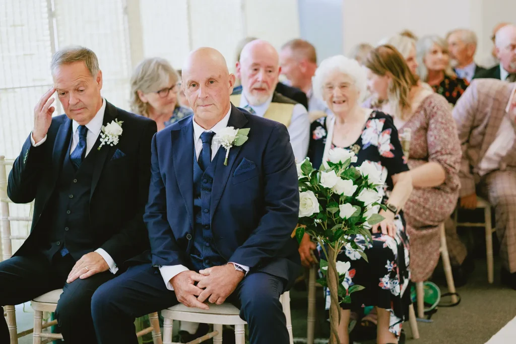 Wedding guests reacting during the ceremony at The Angel Hotel, Alton, Hampshire