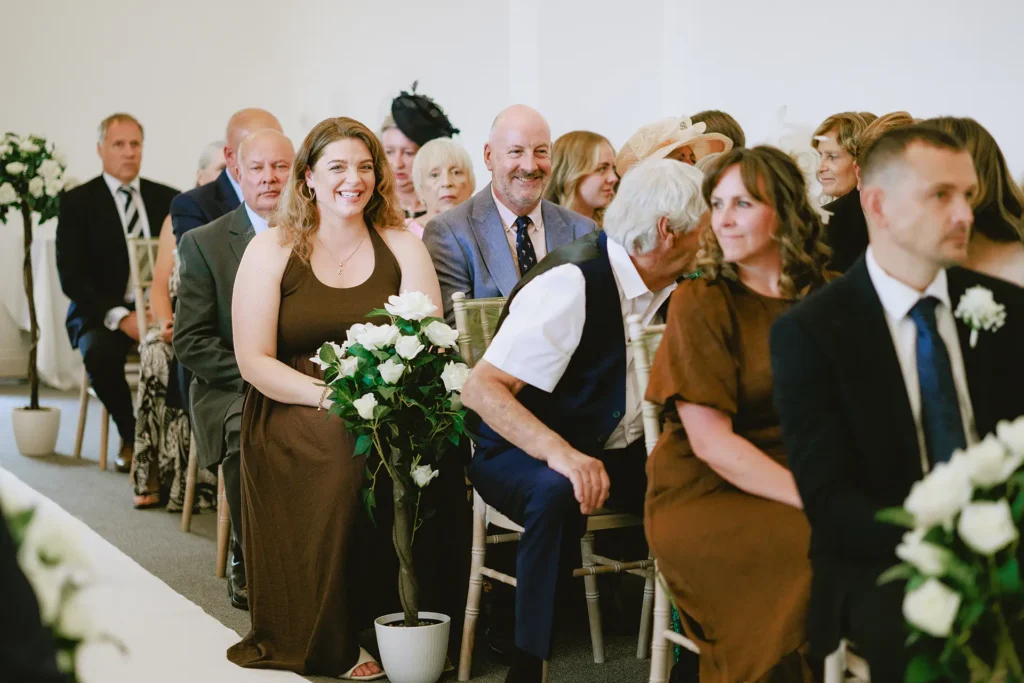 Wedding guests reacting during the ceremony at The Angel Hotel, Alton, Hampshire