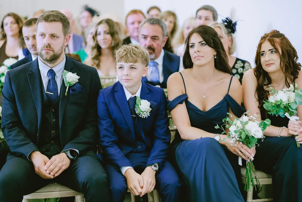 Wedding guests reacting during the ceremony at The Angel Hotel, Alton, Hampshire