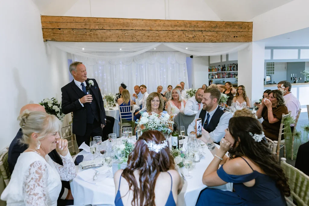 Wedding guests laughing during speeches at The Angel Hotel, Alton, Hampshire