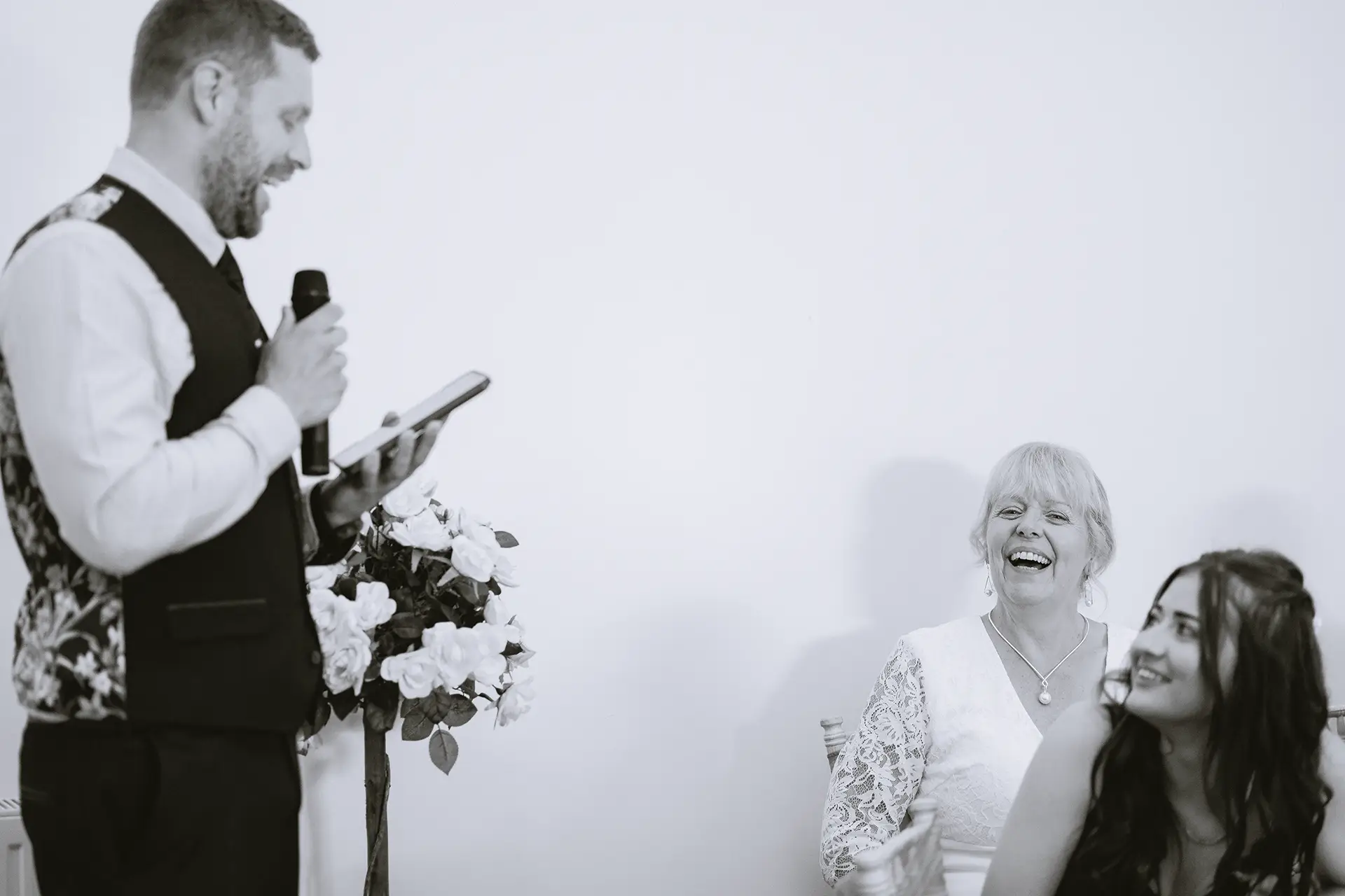 Wedding guests laughing during speeches at The Angel Hotel, Alton, Hampshire