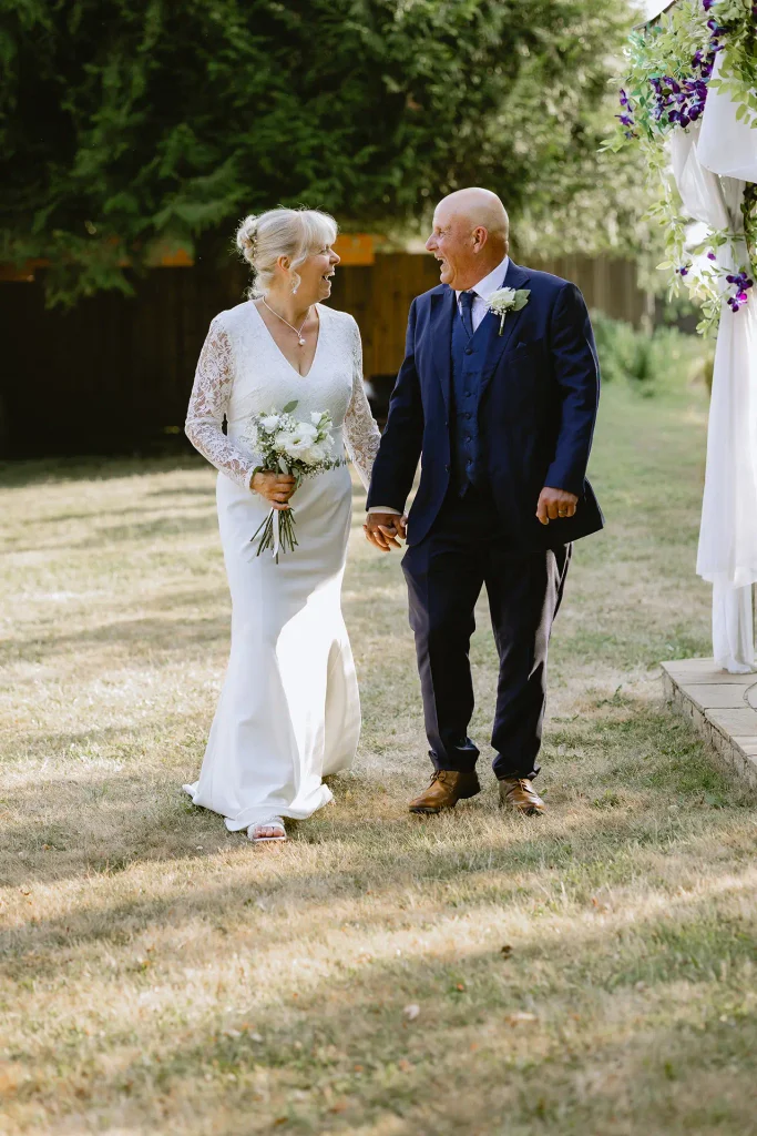 Sarah & Martin walking together in the gardens at The Angel Hotel, Alton — wedding portrait